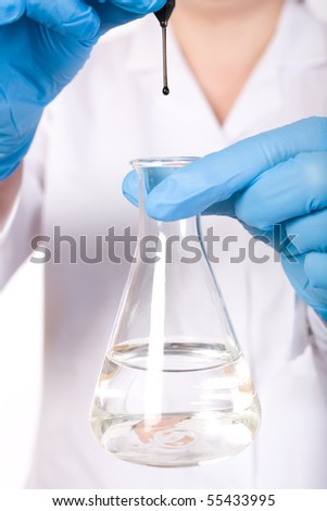 lab assistant making some laboratory tests, black fluid being dropped to test tube filled with clean water