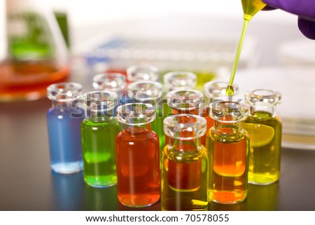 laboratory colorful test tubes, pipette with yellow fluid over one of the bottles, science, experiment