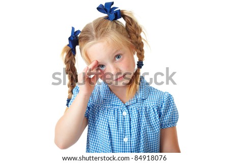 stock photo Blonde schoolgirl in blue dress and pigtails makes some funny