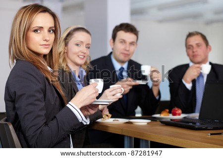 Business team having a coffee break during their meeting, all hold small coffee cups