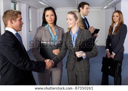 Group of 5 young business people, handshake welcome gesture, office shoot