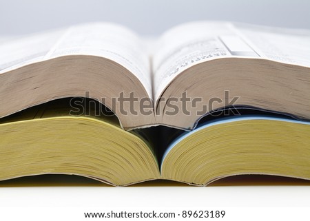 two open telephone books, one with white one with yellow pages