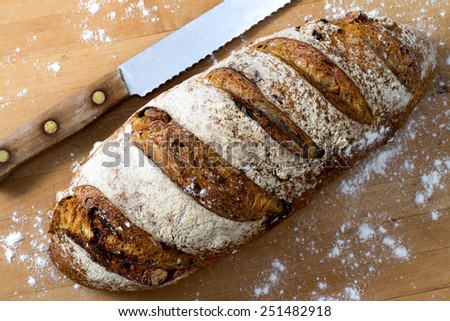 A fresh loaf of cranberry walnut bread and a bread knife