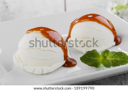 white ice cream ball on a plate with caramel