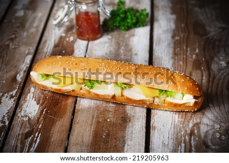 Sandwich with chicken pineapple and cheese on a wooden surface