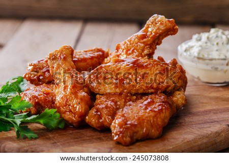 Battered chicken wings in red spicy sauce