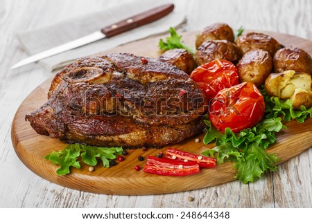roasted pork shoulder on the bone with potatoes