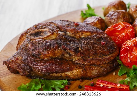 roasted pork shoulder on the bone with potatoes