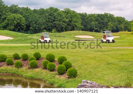 Perfect wavy ground with nice green grass on a golf field  with golf carts