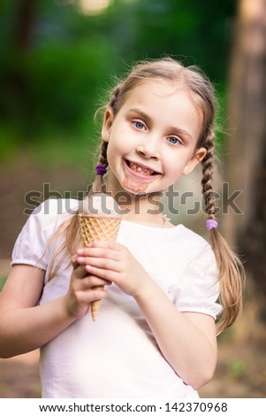 Happy cute child eating ice cream outdoor