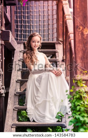 Charming little girl in a beautiful dress in a park outdoor