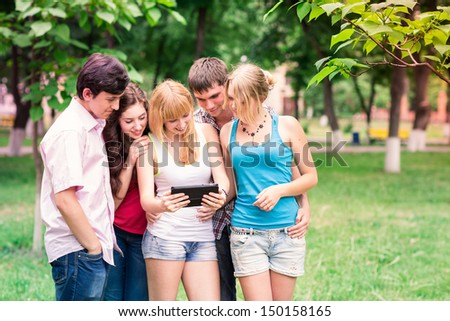 Group of happy smiling Teenage Students looking in tablet pc