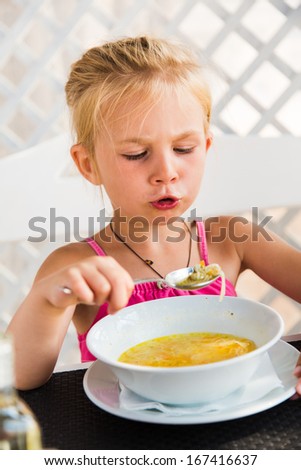 Cute child eating soup from the bowl, healthy food