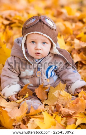 Cute baby in autumn leaves. First autumn