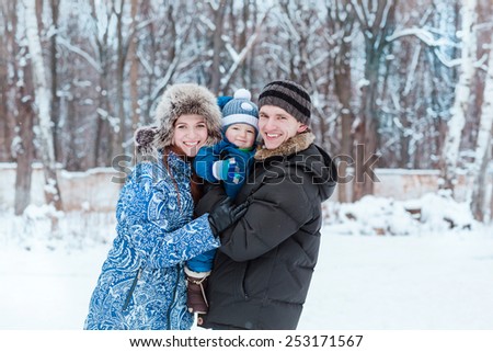 Happy family playing on snow in winter time