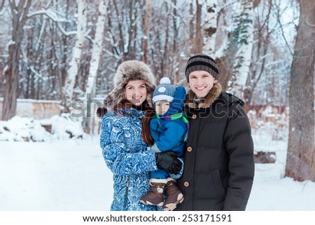 Happy family playing on snow in winter time