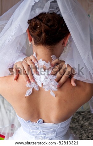 Bride\'s back with her hands on a neck