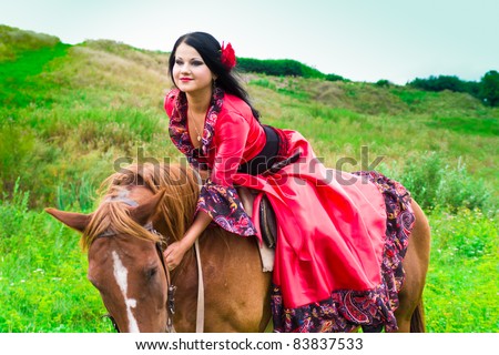 stock photo : Beautiful gypsy girl riding a horse in the field