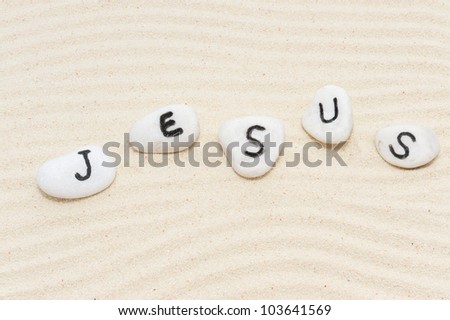 Jesus word on group of stones with sand background