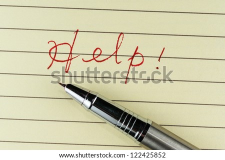 Help word written on lined paper with a pen on it