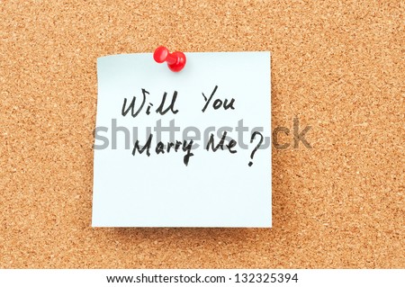 Will you marry me words written on paper and pinned on cork board