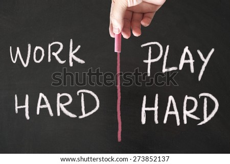 Work hard and play hard words written on blackboard using chalk