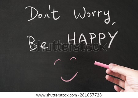 Don\'t worry, be happy words written on the blackboard using chalk