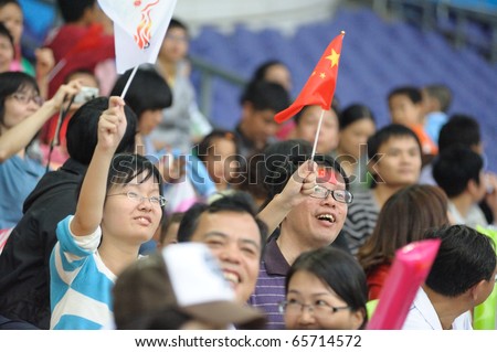 GUANGZHOU, CHINA - NOV 21: An unidentified Chinese couple cheer at the China and Asian Games on Nov. 21, 2010 in Olympic Sports Center,  Guangzhou, China.