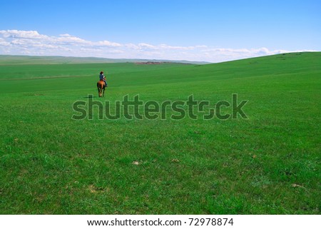 Horseback rider in grassland of Hulun Buir League of Inner-Mongolia, China