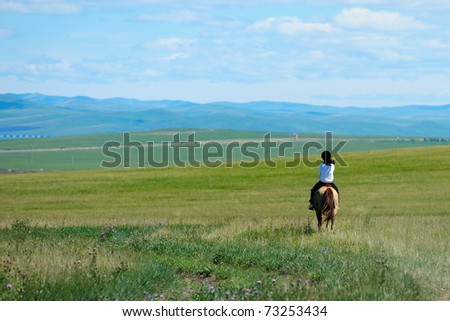 Riding horse in grassland of Hulun Buir League of Inner-Mongolia, China
