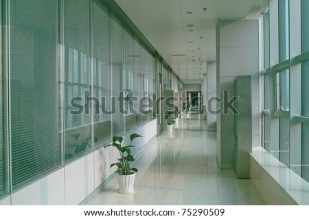 Long hallway in the modern office building with windows