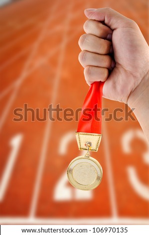 Athletic holding golden medal in Start Running track