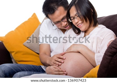 Lovely pregnant with her husband used hand  touched torso for feeling love their baby in studio