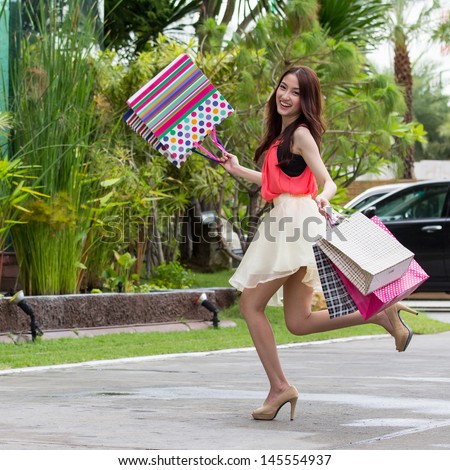 Asian women on holding a lot of shopping bag in Super market