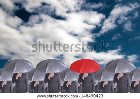 Leader holding red umbrella for show different think with blue sky