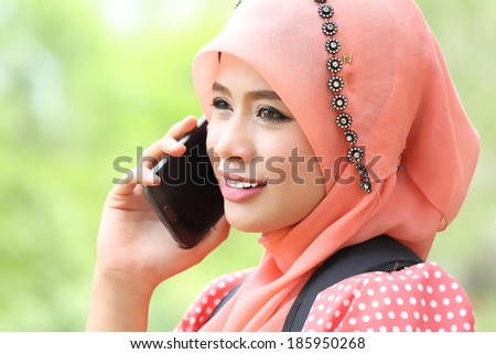 Woman hold smartphone call to talk with friend in the garden.