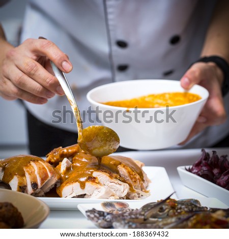 Close up Chef apply chicken soup to Roast Turkey in restaurant