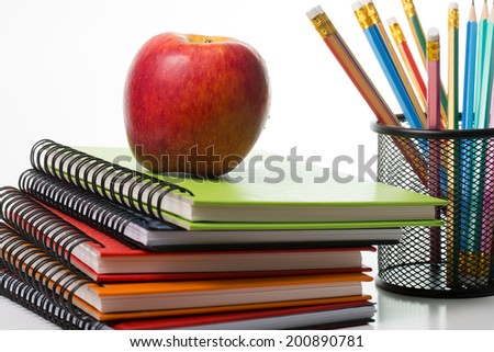 Apple on top colorful books isolated with white background