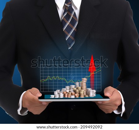 Businessman holding touch pad and growing finance for show case growing graph