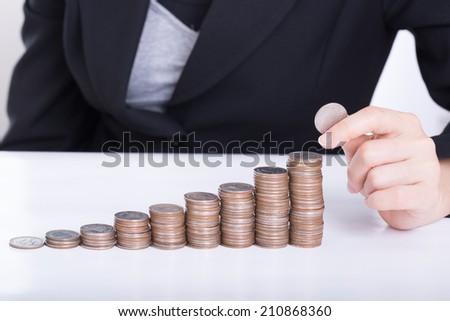 Business women put coin stack money for money growth concept