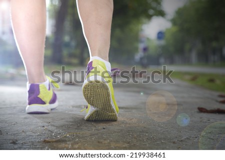 Runner jogging beside garden road in the morning