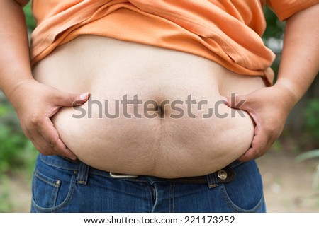 Fat man used hand for check his weight with overweight concept