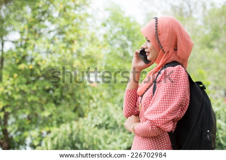 Woman hold smartphone call to talk with friend in the garden