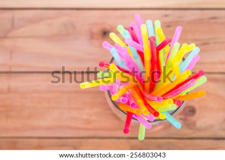 Colorful plastic  straws on the wood board.