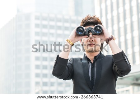 Businessman search stock through binoculars for check and predict trend marketing