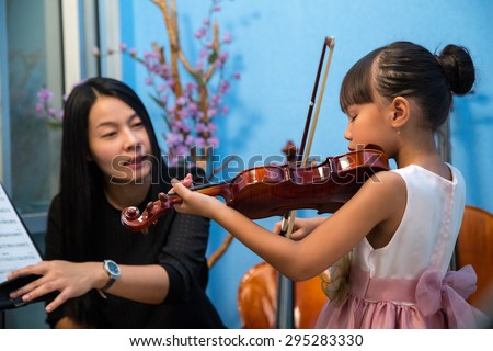 Violinist teacher teach student with violin in studio school.