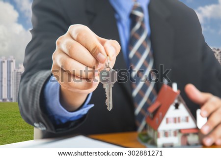 Businessman show Keys for your good property with real agency property.