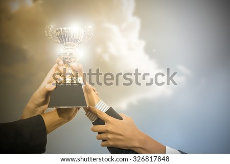 Business people holding trophy award after win competitor.