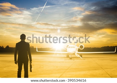 Businessman stand for go to passenger Jet airplane stop for wait VIP passenger on runway.