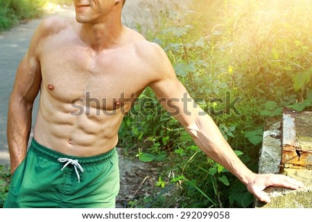 Close up on Strong muscular man abs, summer outside workout